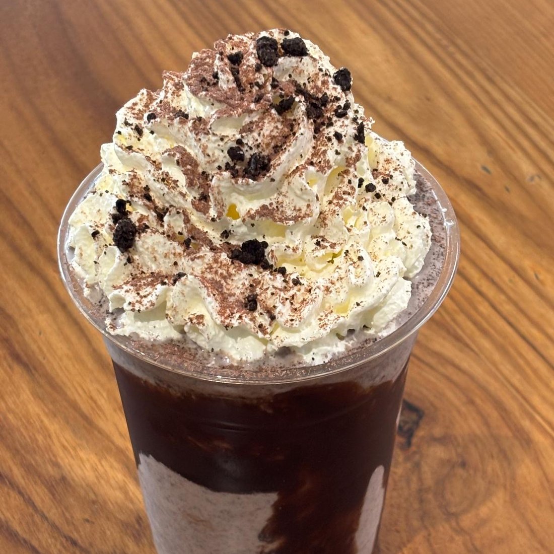 Iced mocha topped with whipped cream and chocolate crumb
