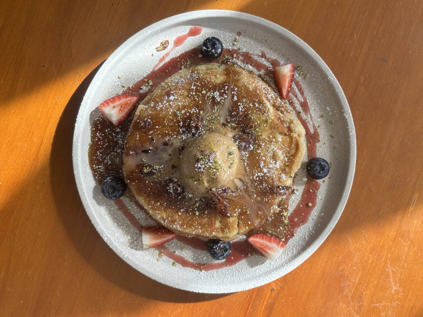Stack of pancakes with berries and maple syrup